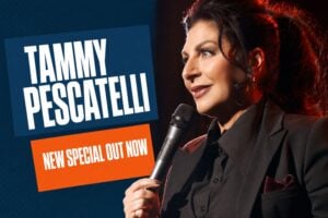 Comedian Tammy Pescatelli performing stand-up with a microphone on stage